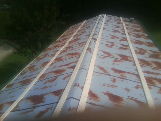 Rusted metal roof panels with new wood purlins before replacement — Storm Damage Roof Repair in Newberry by Roofing Brothers
