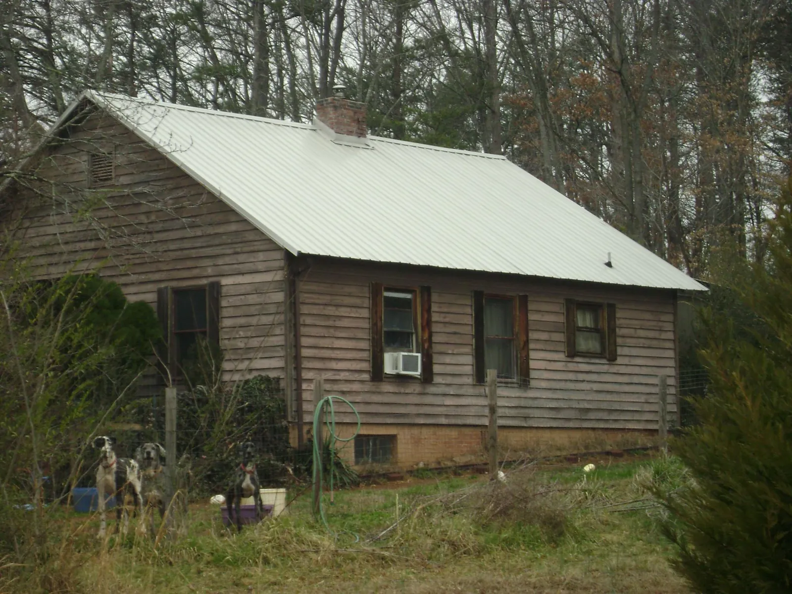 White metal roof on an old wood sided farmhouse, from a Metal Roof Installation job in Newberry